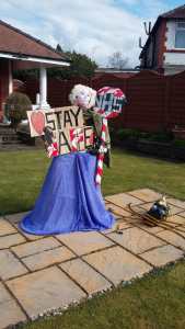 Lydia with a sign saying Stay Safe and a crossing patrol lollipop with NHS written on it
