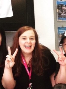 Lucy with her school ID card lanyard round her neck, making victory signs