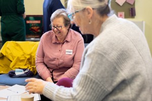 Two participants laughing at looking at something on a table