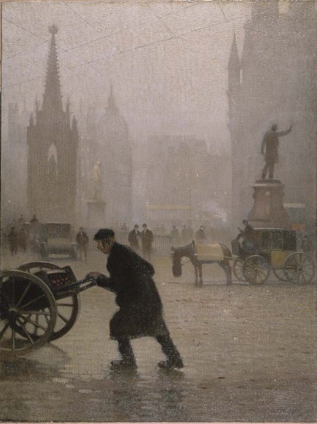 Image: Albert Square on a rainy day in early 20th century Manchester. In the foreground is a man dressed in a long coat and wearing a cloth cap, pushing a handcart across the cobbles. Other people and horse driven carriages are visible in the distance, as well as the Albert memorial and other statues.