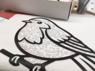 Illustration of a bird with a stylized outline and filled with handwritten text, resting on a branch.