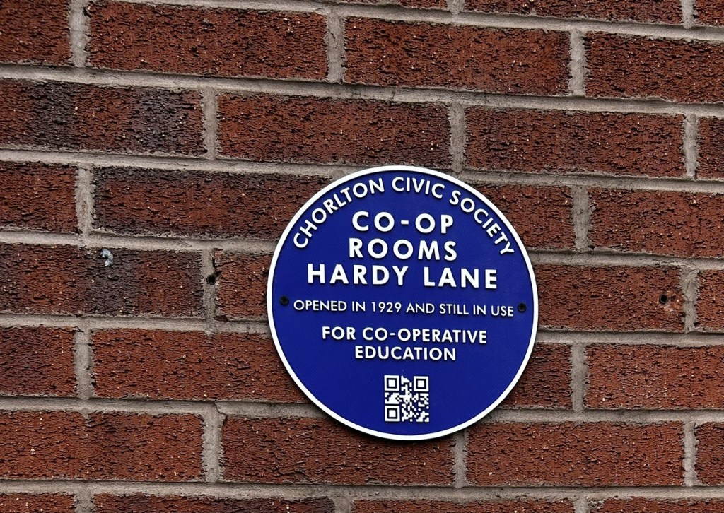 The circular blue plaque has the following text:  Chorlton Civic Society, Co-op Rooms Hardy Lane, opened in 1929 and still in use for Co-operative Education