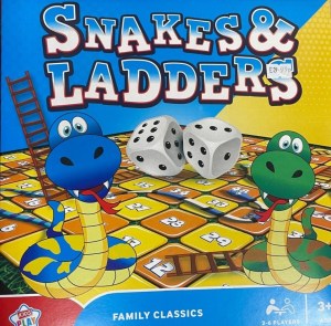Image description: A photograph of the box cover of a game of Snakes and Ladders for children aged three upwards, with two large smiling blue and green snakes rising up from the squared board, with one upright ladder behind them, and one lying down.  There are two dice in the centre of the image.  